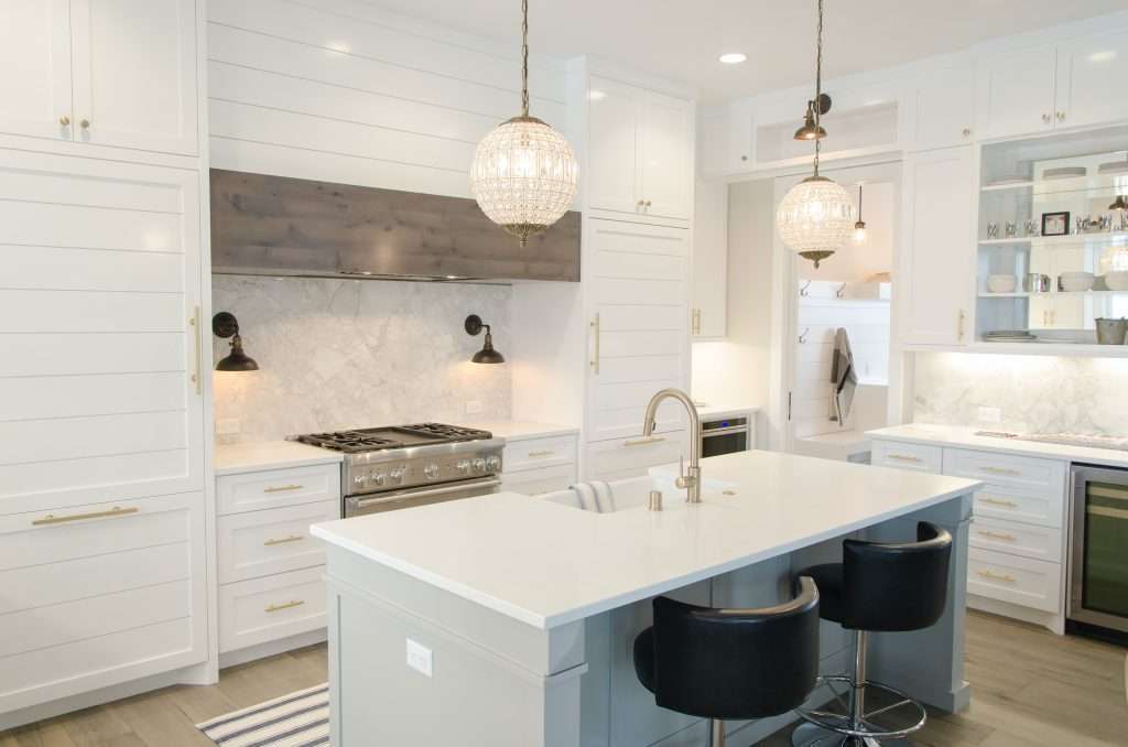 a white kitchen room with black chairs