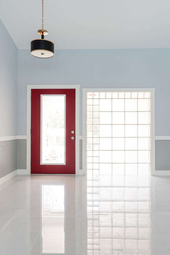a red and white wooden door inside a white room