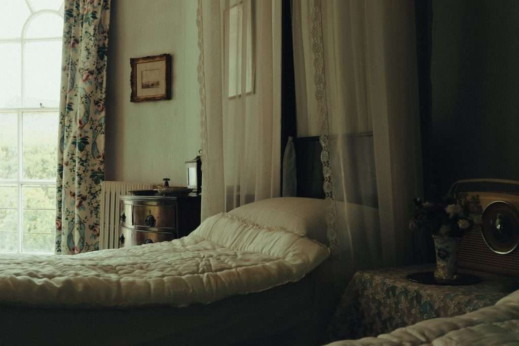 an interior of a Victorian bedroom with a white curtain