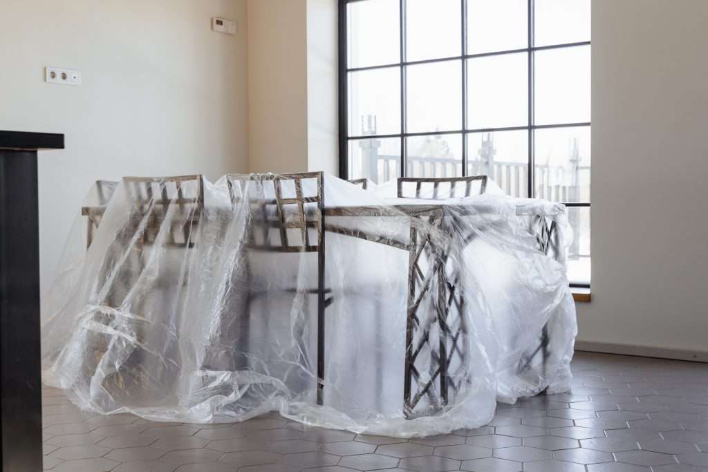 A Dining Table and Chairs Covered with Plastic
